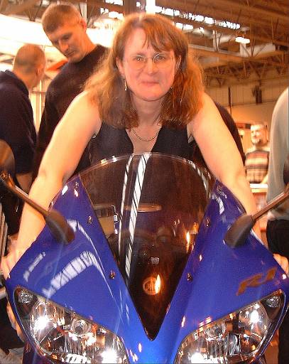 bikeshow2001-013.jpg - Yvonne on R1. Very fast. But not as fast as the GSXR1000. So its being slightly revamped. I predict more power and lighter weight. But Yvonne prefers the Blade. And what's that bloke looking at.
